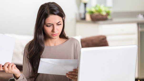 distraught woman paying her bills at home