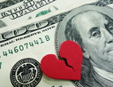 A broken red heart over two US hundred dollar bills