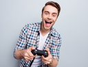 Excited guy in checkered shirt holding joystick