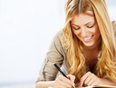 Portrait of a cheerful blonde woman writing diary