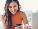 Smiling woman with credit card and laptop