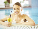 Woman lounging at hotel pool with drink