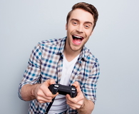 Excited guy in checkered shirt holding joystick
