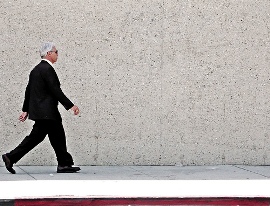 man in suit walking on sidewalk